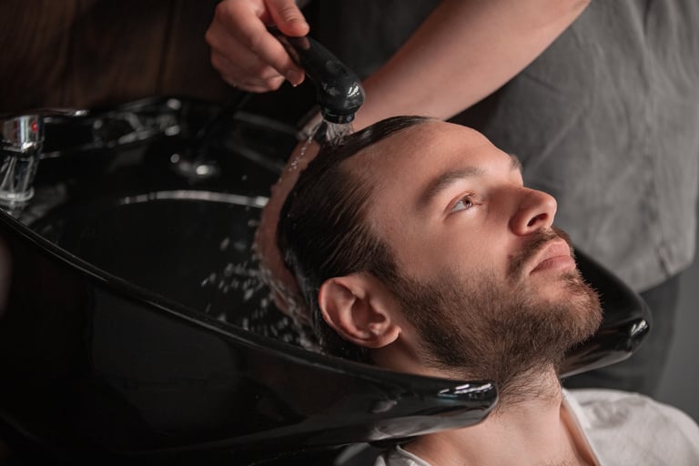 Barber rinsing client's hair