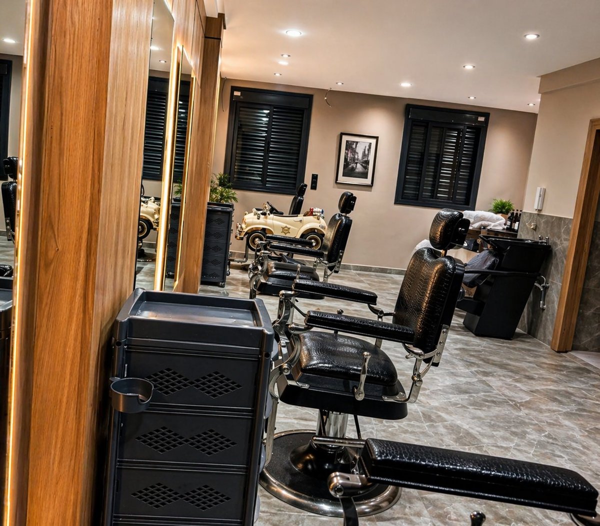 Modern barbershop interior with black barber chairs, styling stations, and wooden framed mirrors under recessed lighting.
